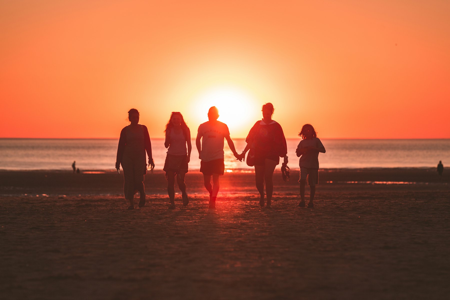 A family together in a field at sunset